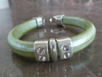 Pulseira de couro verde metalizado decorada com motivos prateados